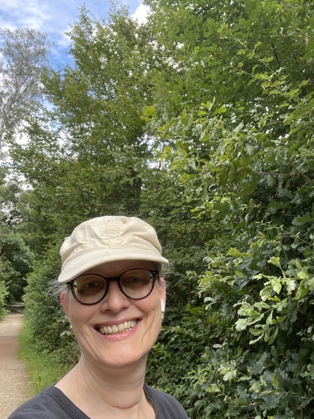 selfie in a beige cap, glasses and an old black tee on the same path