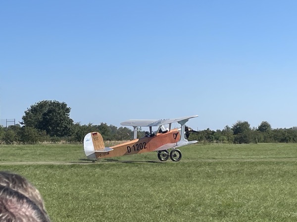 a red and white biplane on a meadow