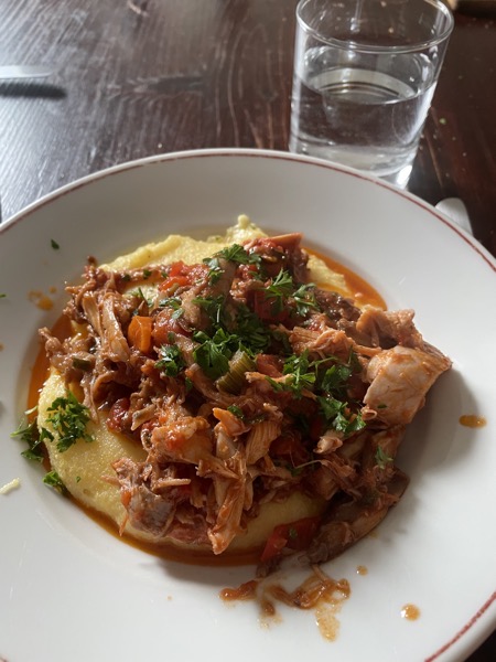 polenta, rabbit and tomato sauce with a glass of water