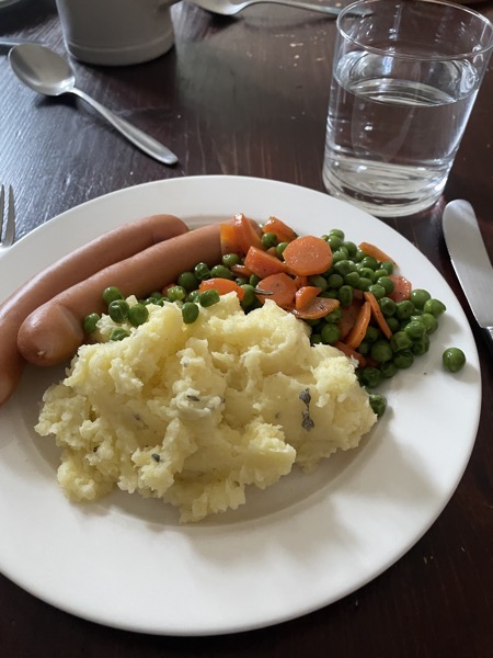 winers, mashed potatoes, peas and carrots and a glass of water