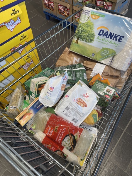 grocery cart full of groceries and paper towels