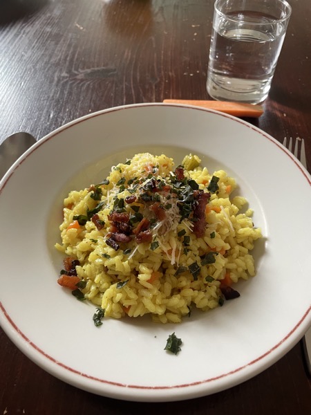 risotto with guanciale, a raw carrot and a glass of water