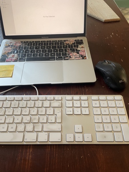 an open laptop connected to a white keyboard with very dirty keys and a black mouse